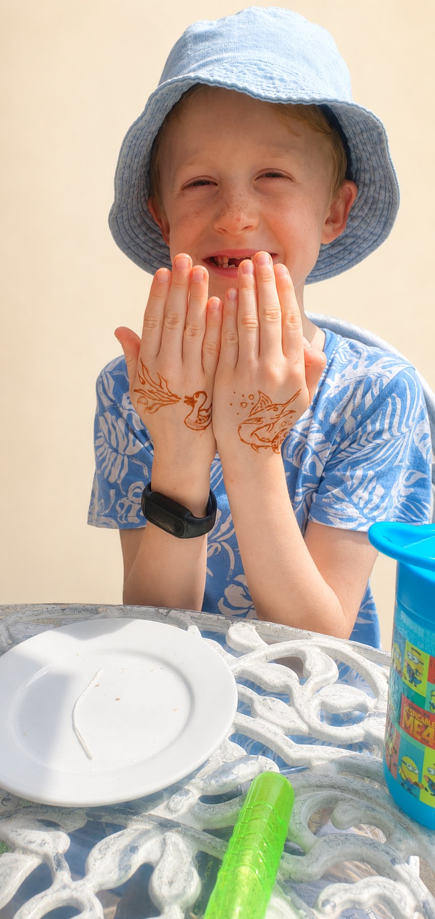 Young boy showing a fire-breathing duck on one hand and a swordfish on the other, in next-day colour