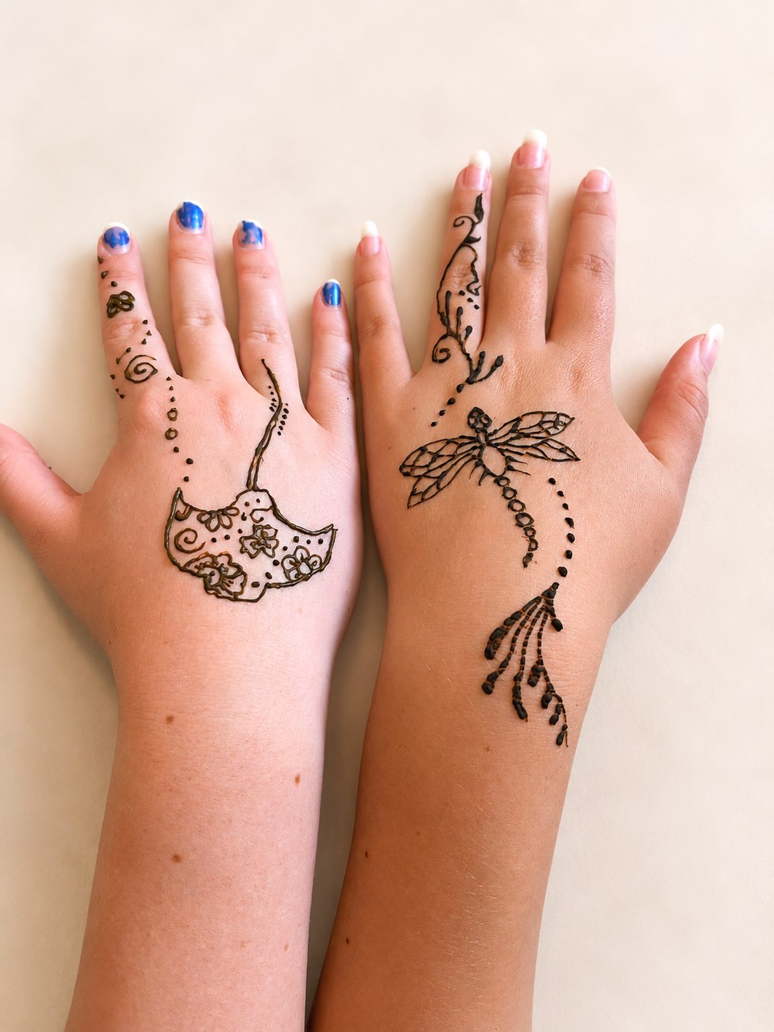 Stingray henna on one hand and a detailed dragonfly on the other