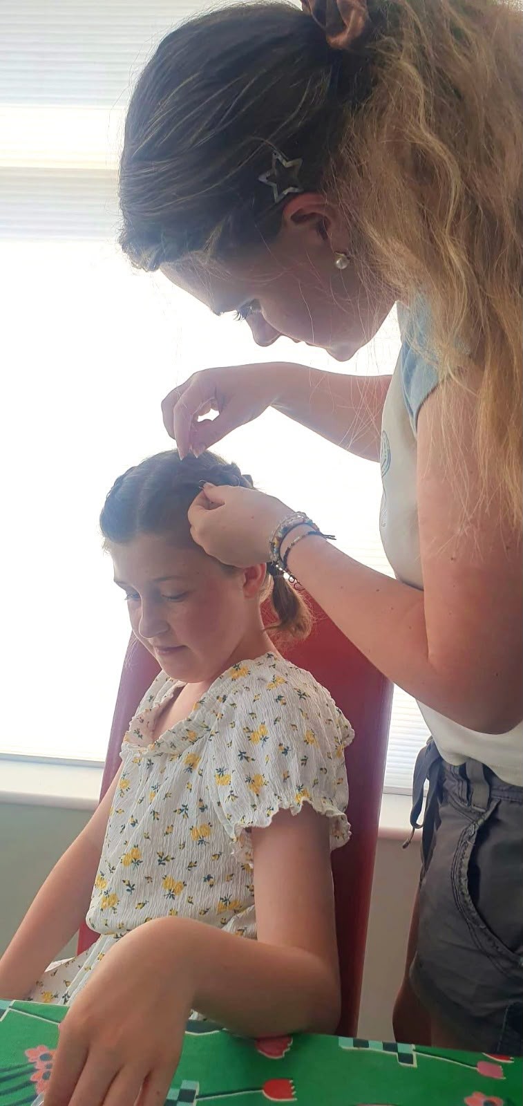Emma concentrating while pinning a braid into place